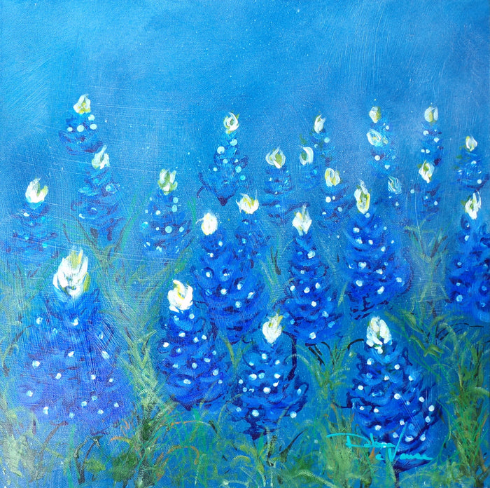 a Sea of bluebonnet blooms fading into a light blue background. Blue flower blooms with white and yellow points at top. 